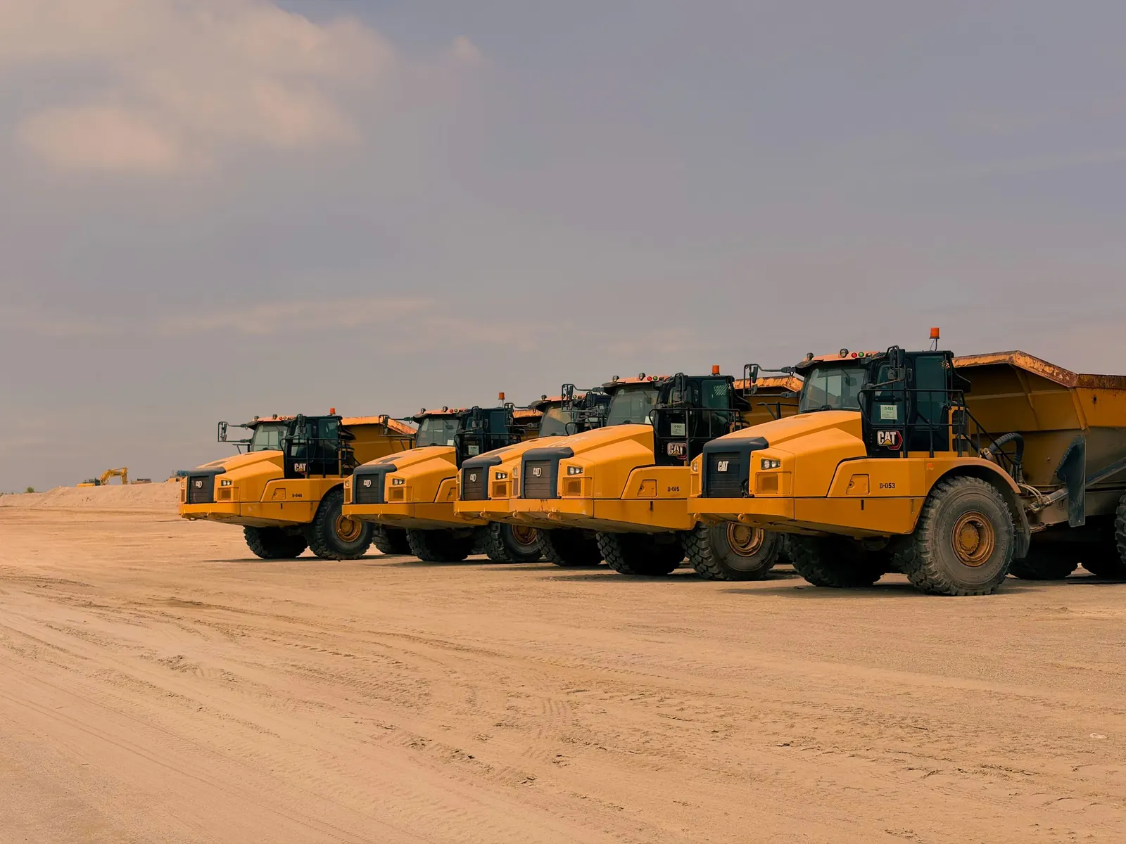 A row of dump trucks on a site